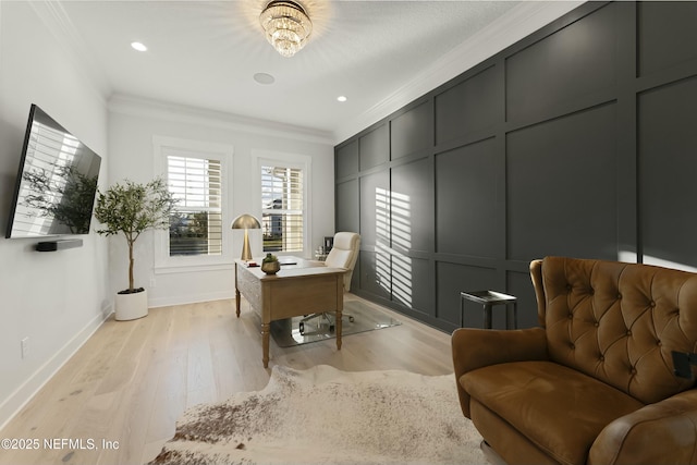 office area featuring a decorative wall, light wood-style flooring, crown molding, and baseboards