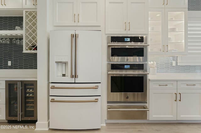 kitchen with beverage cooler, high end white refrigerator, white cabinets, and light countertops