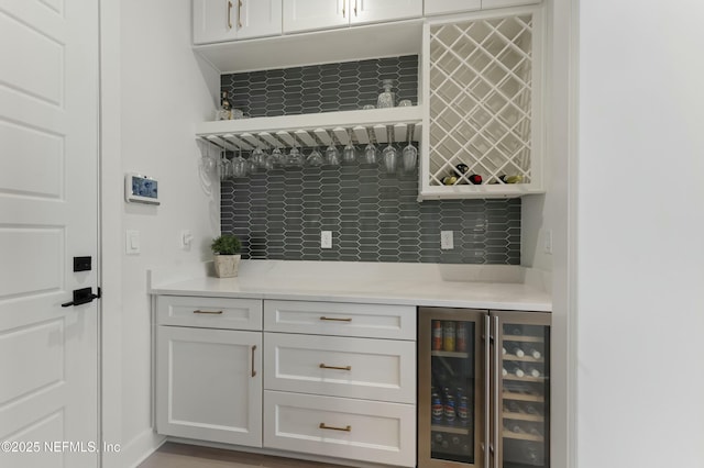 bar with beverage cooler, bar, and backsplash