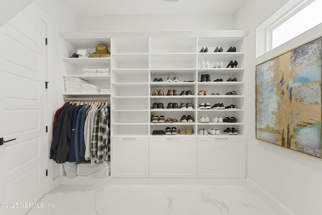 walk in closet featuring marble finish floor