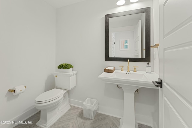 half bath with toilet and baseboards