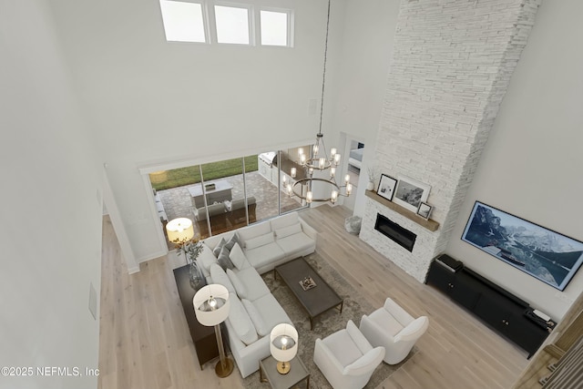 unfurnished living room with a fireplace, wood finished floors, and a towering ceiling