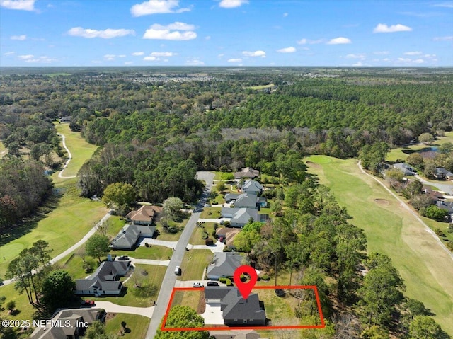 drone / aerial view with a forest view and view of golf course