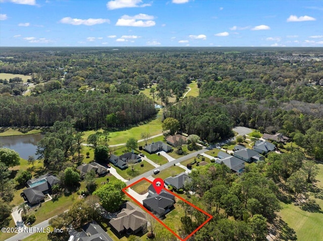 drone / aerial view with a forest view, a water view, and a residential view