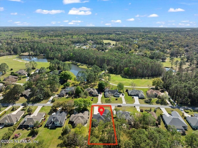 drone / aerial view featuring a residential view, a water view, and a wooded view