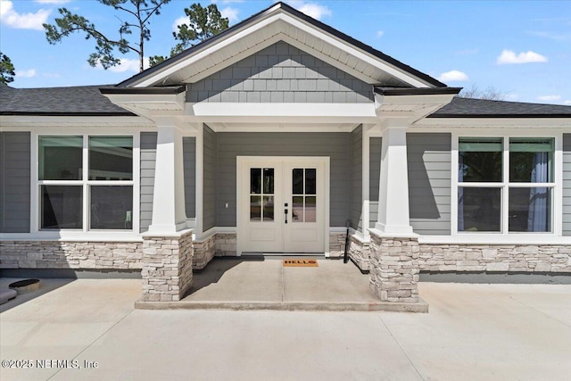 doorway to property featuring french doors and stone siding