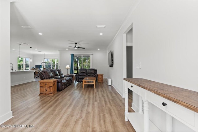 living area featuring a ceiling fan, crown molding, recessed lighting, and light wood-style floors