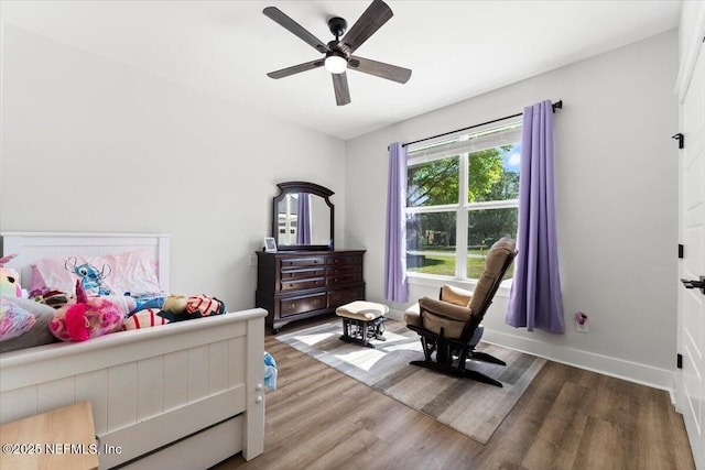 bedroom with ceiling fan, baseboards, and wood finished floors