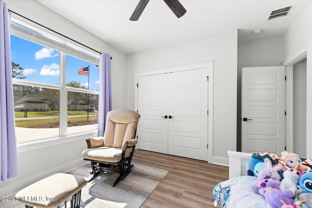 bedroom featuring visible vents, a ceiling fan, wood finished floors, a closet, and baseboards