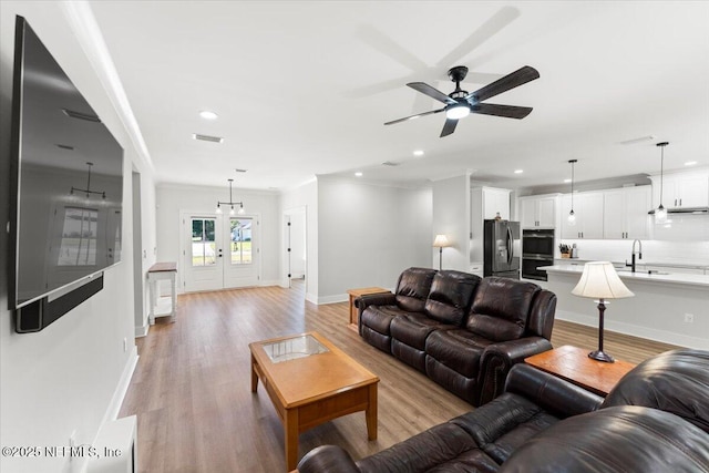 living room with recessed lighting, light wood-type flooring, ceiling fan, and ornamental molding