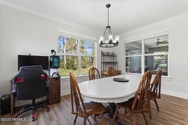 dining area featuring crown molding, a notable chandelier, wood finished floors, and baseboards