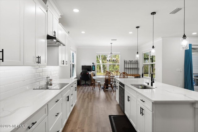 kitchen with visible vents, a sink, black appliances, crown molding, and backsplash