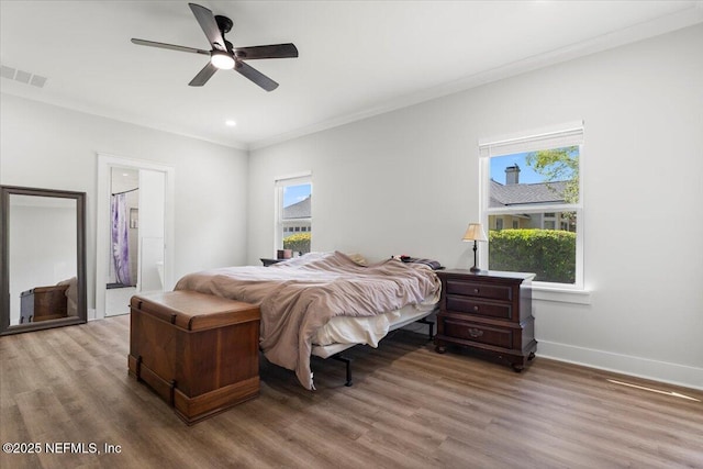 bedroom featuring visible vents, multiple windows, and wood finished floors