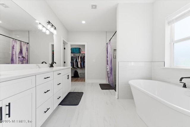 bathroom with a soaking tub, visible vents, a shower with curtain, and double vanity