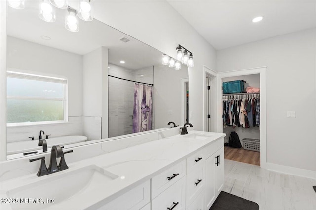 bathroom with a shower with shower curtain, double vanity, a freestanding bath, and a sink