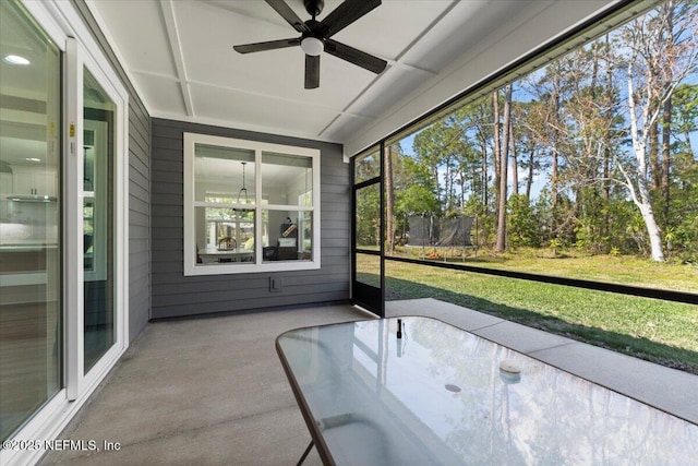 unfurnished sunroom featuring a ceiling fan