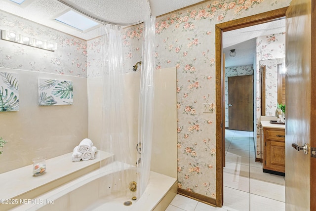 bathroom featuring a textured ceiling, a jetted tub, tile patterned flooring, and wallpapered walls