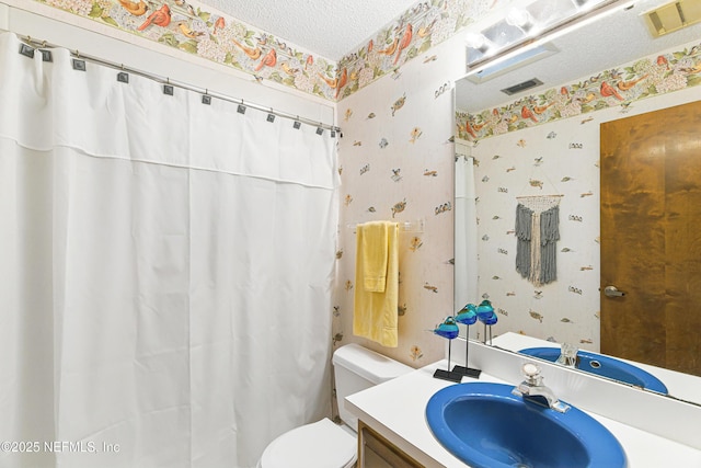 bathroom featuring visible vents, toilet, a textured ceiling, vanity, and wallpapered walls