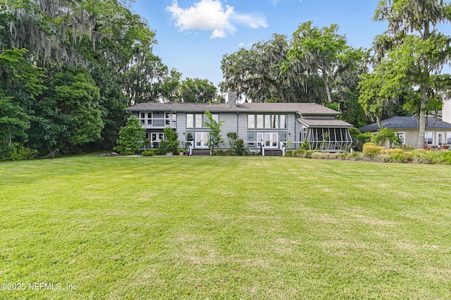 back of house with a lawn and a chimney