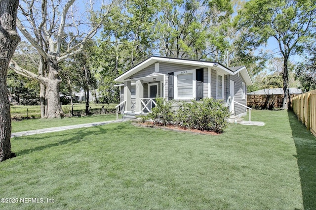 bungalow featuring a front lawn and fence