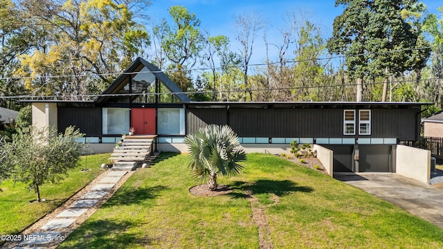 view of front facade with a front yard, an attached garage, and driveway