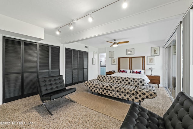 bedroom with a ceiling fan, speckled floor, and two closets