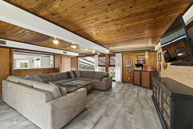 living room with visible vents, wooden walls, wood ceiling, and rail lighting