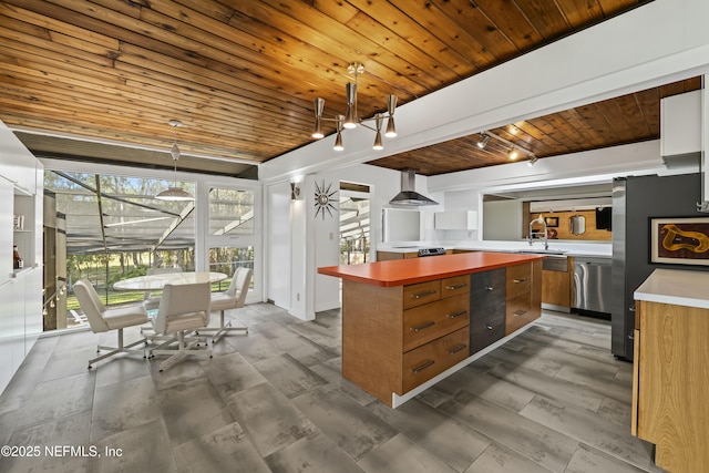 kitchen featuring wood ceiling, brown cabinets, appliances with stainless steel finishes, rail lighting, and wall chimney exhaust hood