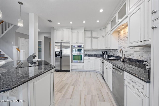 kitchen with white cabinets, visible vents, appliances with stainless steel finishes, and a sink