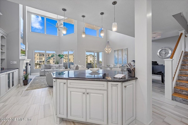 kitchen featuring plenty of natural light, white cabinets, and black electric cooktop