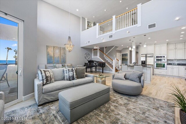 living room featuring light wood-style flooring, recessed lighting, visible vents, and baseboards