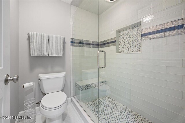 full bath featuring a shower stall, toilet, and baseboards