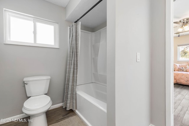 full bath with wood finished floors, baseboards, toilet, shower / tub combo with curtain, and connected bathroom