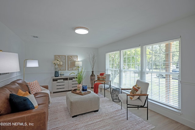 living room featuring visible vents, a healthy amount of sunlight, and wood finished floors