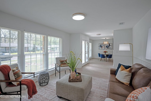 living area featuring visible vents and light wood-style flooring