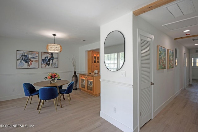 dining area featuring light wood-style floors, visible vents, and baseboards