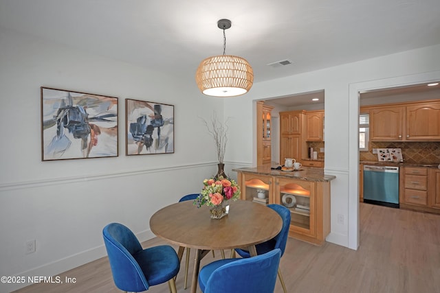 dining area with visible vents, baseboards, and light wood-style flooring