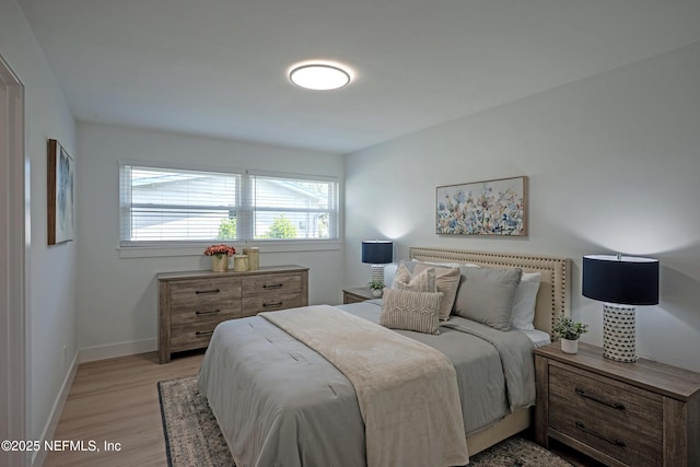 bedroom featuring baseboards and light wood finished floors