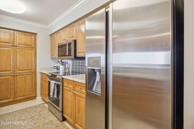 kitchen with light countertops, ornamental molding, light tile patterned floors, appliances with stainless steel finishes, and brown cabinetry