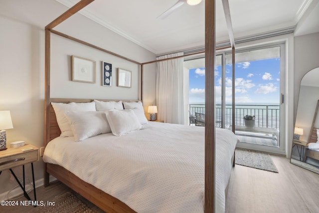 bedroom with a water view, a ceiling fan, access to outside, wood finished floors, and crown molding