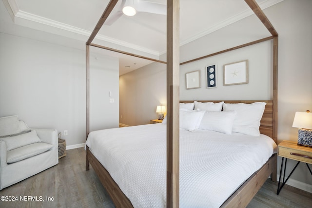 bedroom with crown molding, wood finished floors, and baseboards