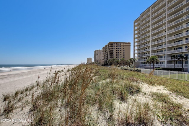 view of water feature featuring fence and a view of the beach