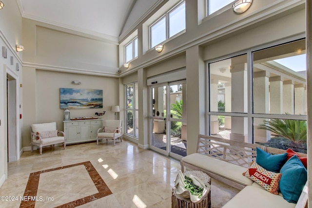 interior space featuring baseboards, marble finish floor, and a towering ceiling