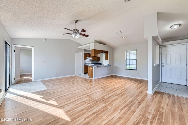 1602 Ibis Dr, Orange Park, FL 32065 - unfurnished living room with visible vents, vaulted ceiling, light wood-style floors, a textured ceiling, and a ceiling fan