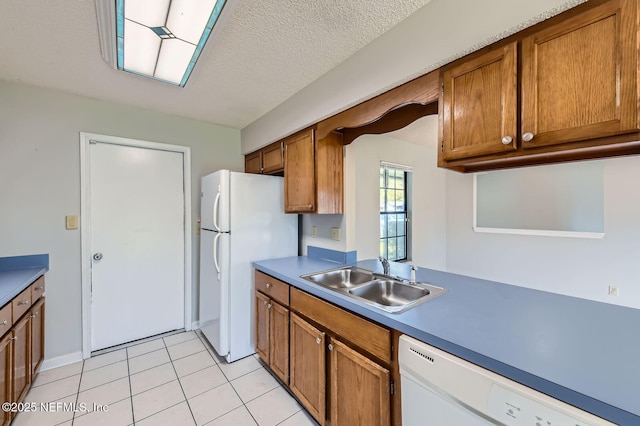 1602 Ibis Dr, Orange Park, FL 32065 - kitchen with light tile patterned floors, brown cabinets, white appliances, a textured ceiling, and a sink
