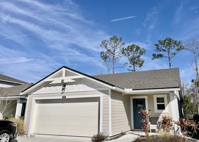 view of front of home featuring board and batten siding, a shingled roof, driveway, and a garage