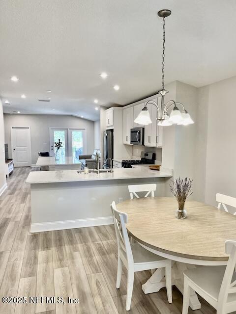 dining area featuring recessed lighting, light wood-style floors, and a chandelier