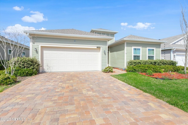 prairie-style home with decorative driveway and a garage