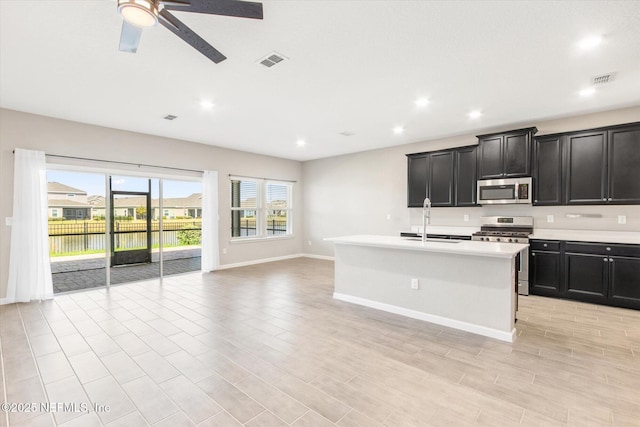 kitchen with visible vents, open floor plan, light countertops, appliances with stainless steel finishes, and a sink