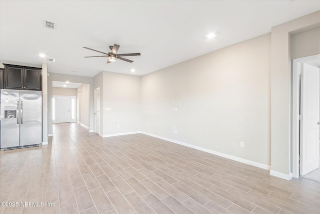 unfurnished room with baseboards, visible vents, light wood finished floors, and ceiling fan